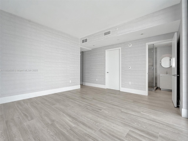 unfurnished bedroom with visible vents, baseboards, and light wood-style floors