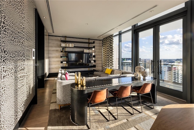 living room featuring wood-type flooring, a healthy amount of sunlight, french doors, and expansive windows