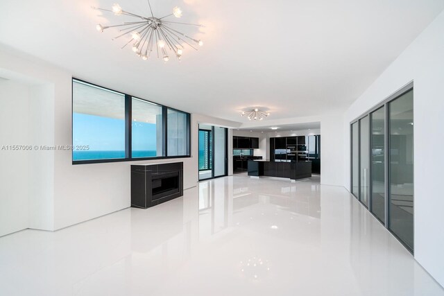 interior space with a notable chandelier, a water view, and light tile floors