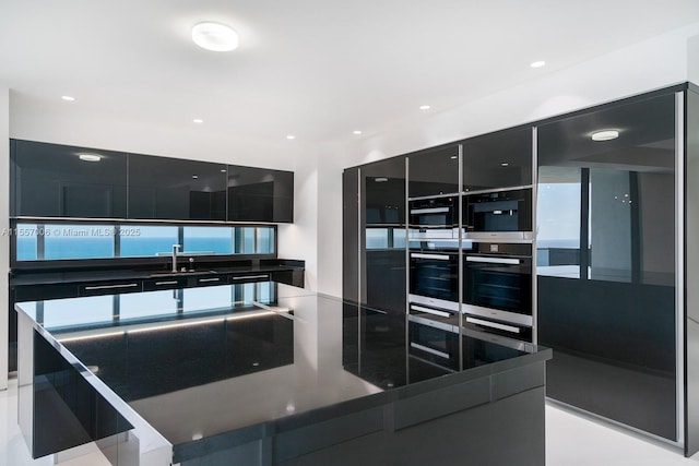 kitchen with fridge, stainless steel double oven, and sink