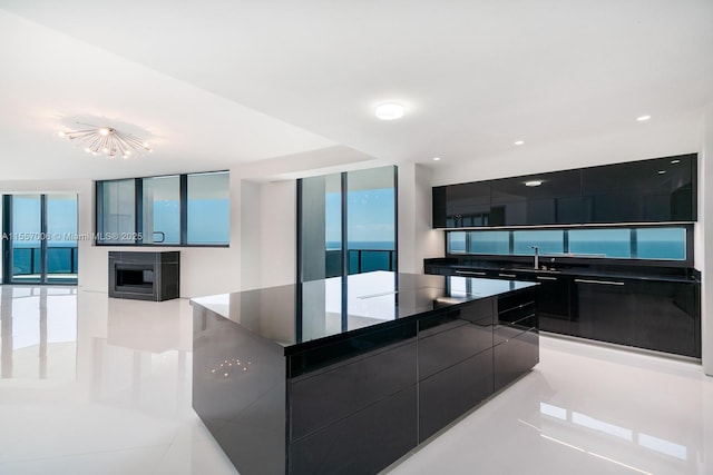 kitchen featuring floor to ceiling windows, a large island, and sink