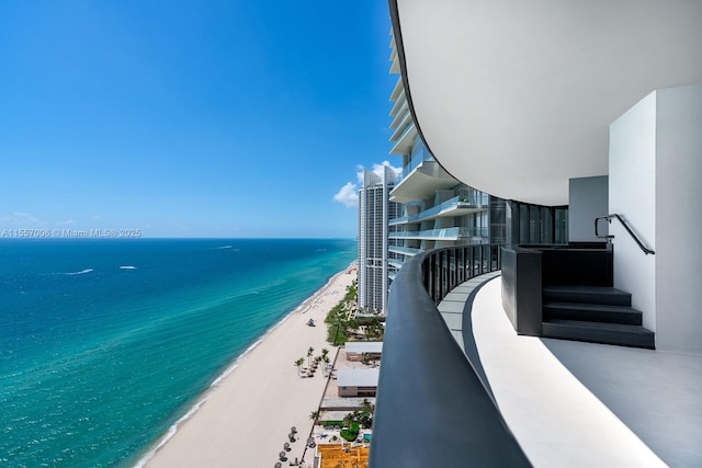 balcony featuring a water view and a view of the beach