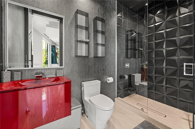 bathroom featuring tiled shower, vanity, and toilet