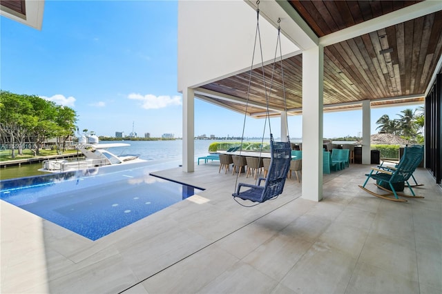 view of pool with a water view and a bar