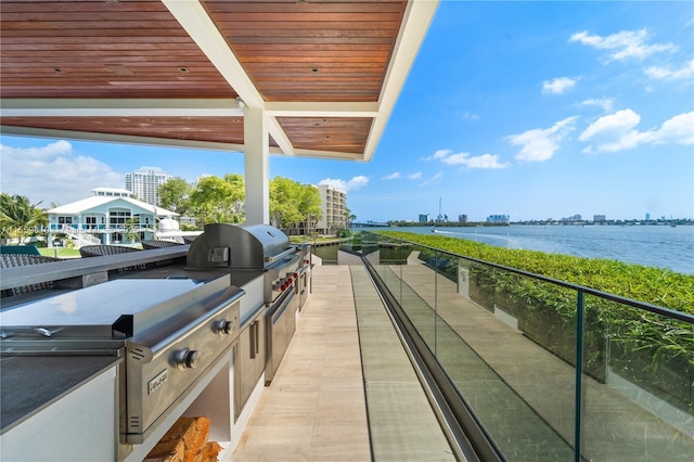 balcony with a water view, area for grilling, and grilling area