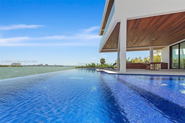 view of pool featuring a patio area and a water view