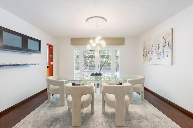 dining area featuring hardwood / wood-style floors and an inviting chandelier