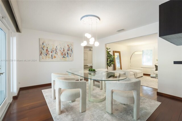 dining room with dark hardwood / wood-style floors and a healthy amount of sunlight