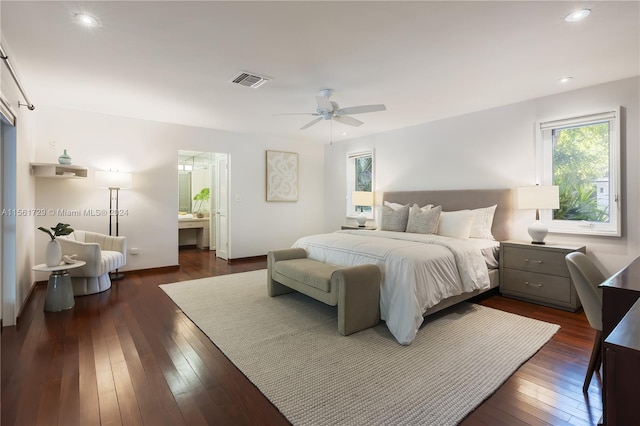 bedroom with ceiling fan, ensuite bathroom, and dark wood-type flooring