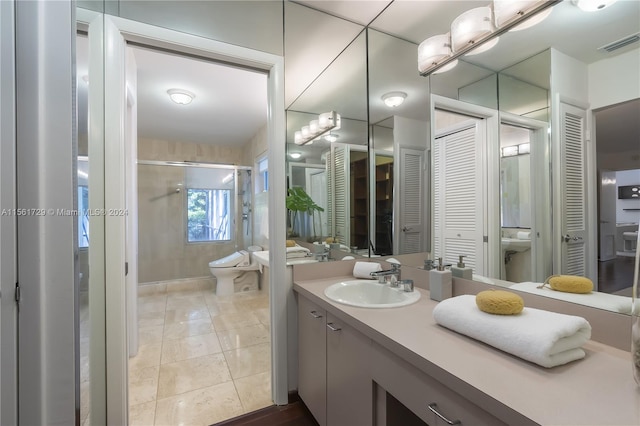 bathroom featuring tile patterned floors, vanity, an enclosed shower, and toilet