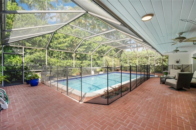 view of pool featuring a patio, glass enclosure, and ceiling fan