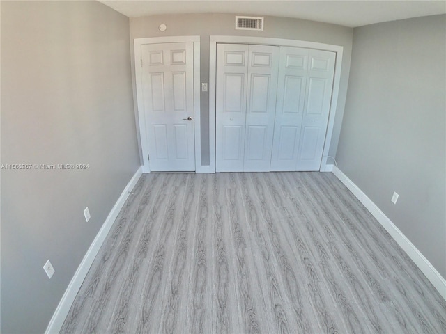 unfurnished bedroom with a closet and light hardwood / wood-style flooring