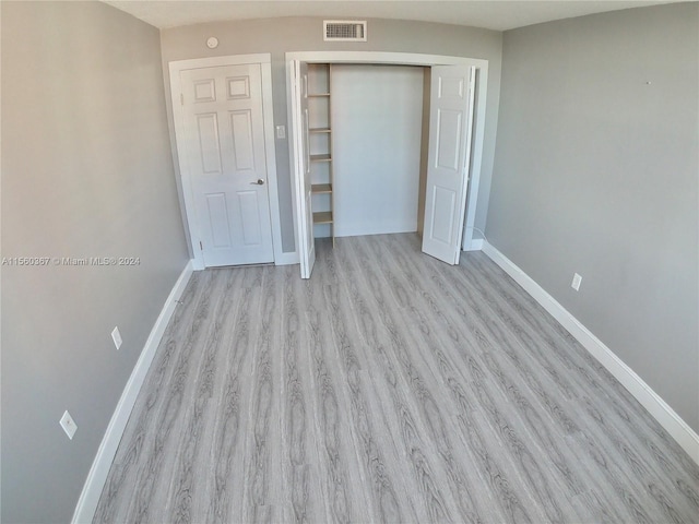 unfurnished bedroom featuring a closet and light wood-type flooring