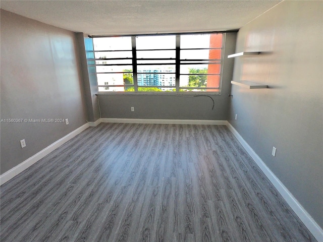 empty room with hardwood / wood-style floors and a textured ceiling