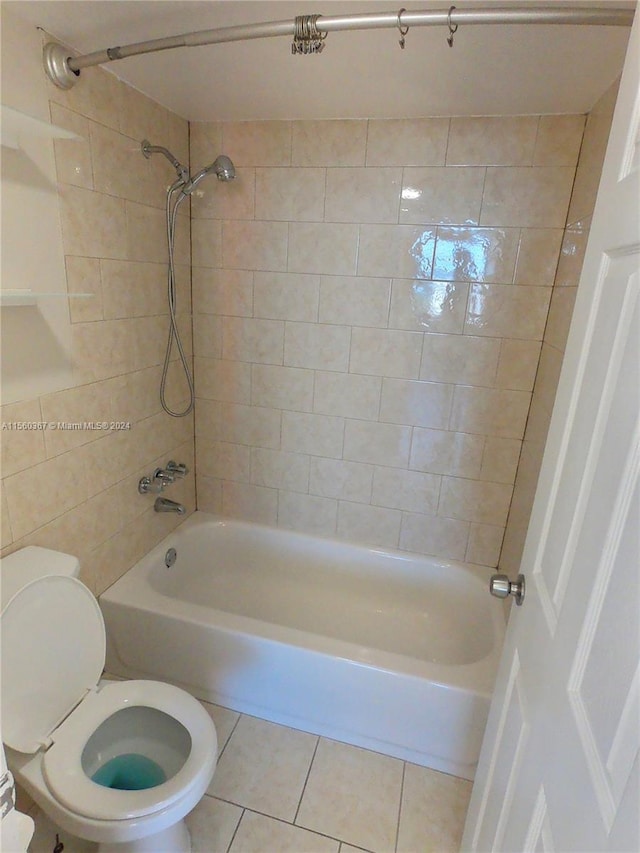 bathroom with tile flooring, toilet, and tiled shower / bath