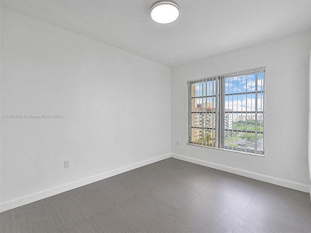 spare room featuring dark tile flooring