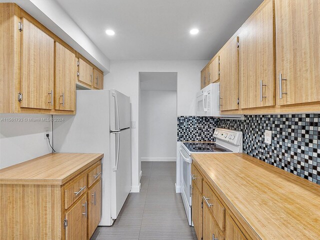 kitchen featuring tile flooring, tasteful backsplash, and white appliances