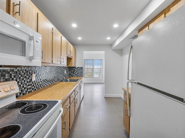 kitchen with light tile flooring, white appliances, sink, light brown cabinetry, and tasteful backsplash