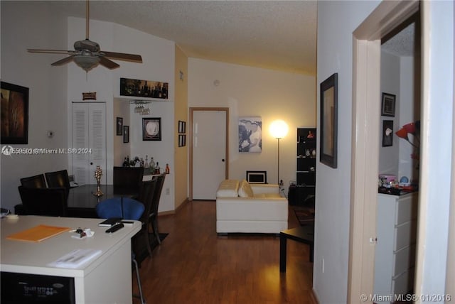 living room featuring lofted ceiling, a textured ceiling, dark hardwood / wood-style floors, and ceiling fan