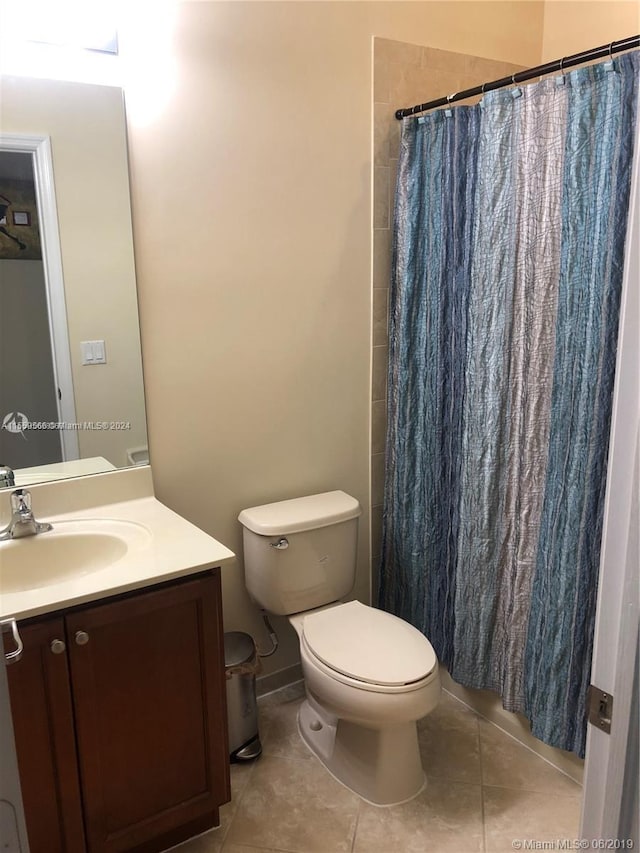 bathroom featuring vanity, tile flooring, and toilet