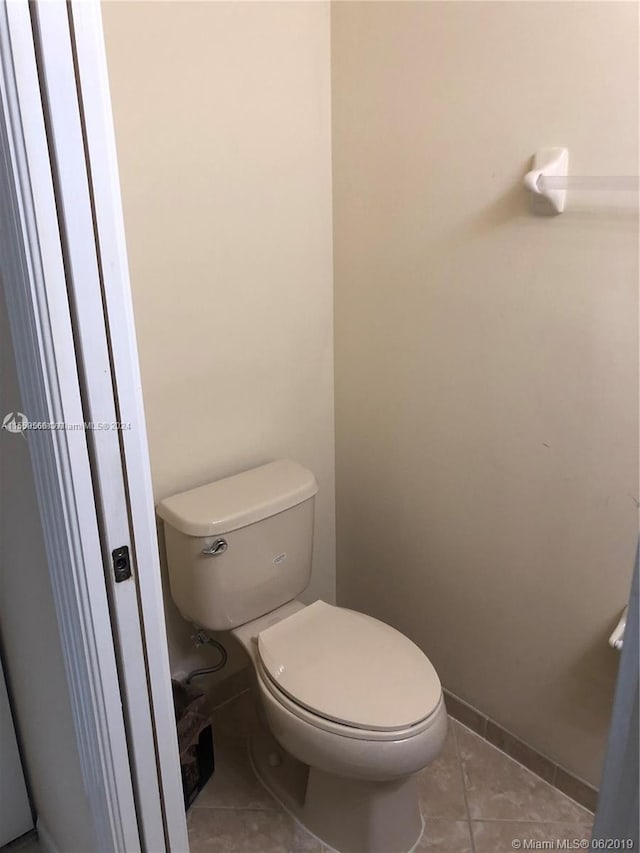 bathroom with tile flooring and toilet