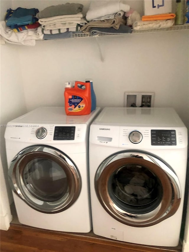 clothes washing area featuring washing machine and dryer, wood-type flooring, and hookup for a washing machine