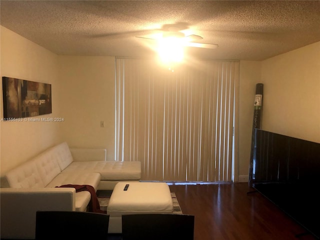 living room with a textured ceiling, ceiling fan, and hardwood / wood-style flooring