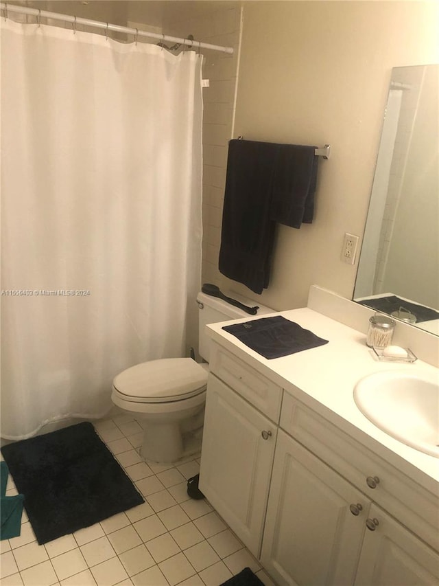 bathroom with toilet, tile floors, and vanity