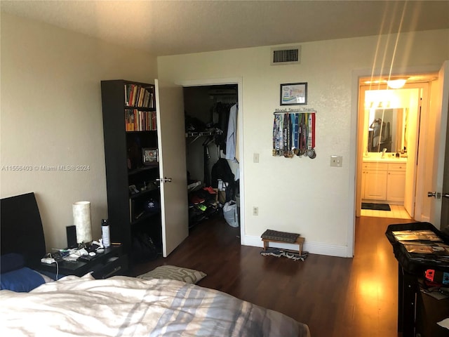 bedroom featuring a closet, a spacious closet, dark hardwood / wood-style floors, and ensuite bathroom