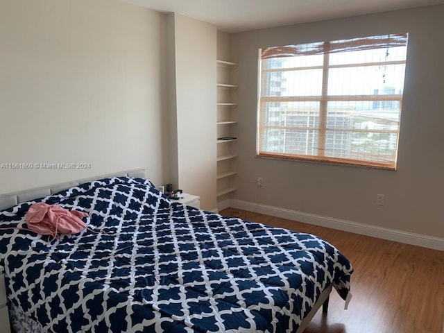 bedroom featuring multiple windows and wood-type flooring