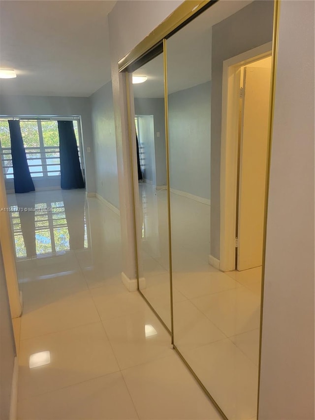 hall with tile patterned flooring and baseboards