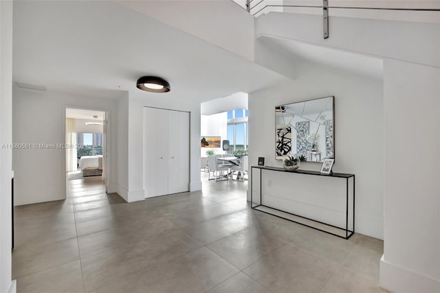 hall featuring vaulted ceiling and tile flooring