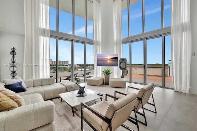 tiled living room featuring a towering ceiling and a wealth of natural light