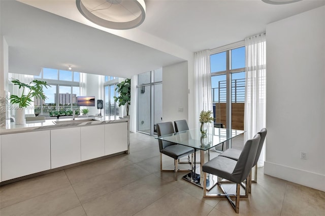 tiled dining room with sink, a wealth of natural light, and expansive windows