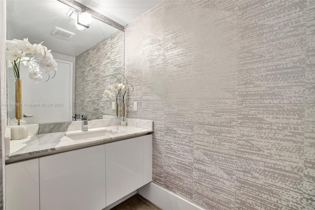 bathroom featuring tile walls and vanity with extensive cabinet space