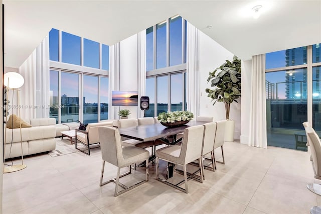 tiled dining space featuring floor to ceiling windows, a water view, and plenty of natural light