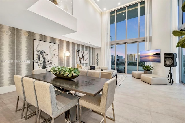 tiled dining room featuring a towering ceiling and expansive windows