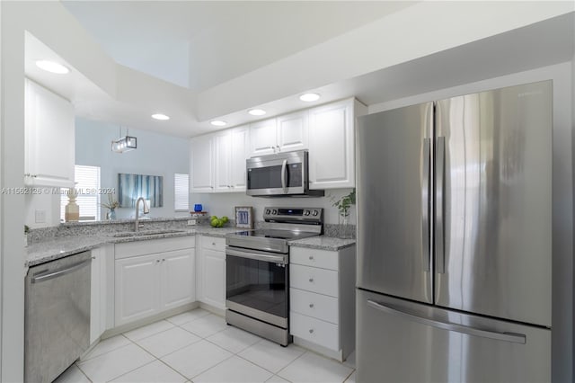 kitchen featuring stainless steel appliances, light tile floors, light stone countertops, white cabinetry, and sink