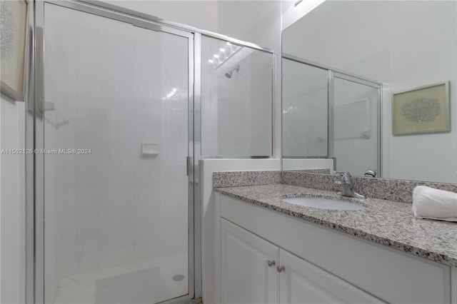 bathroom featuring vanity and a shower with shower door