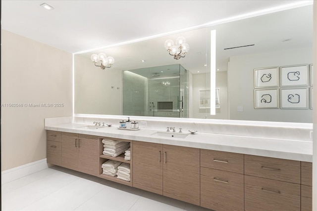 bathroom with tile patterned flooring, vanity, an inviting chandelier, and a shower with shower door