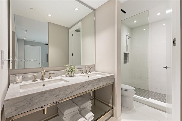 bathroom featuring a tile shower, tile patterned flooring, vanity, and toilet