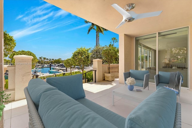 view of patio / terrace featuring ceiling fan, a water view, and an outdoor living space