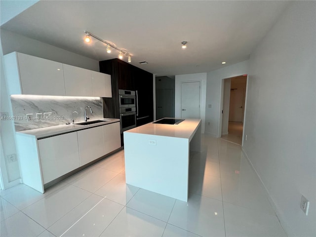 kitchen featuring a kitchen island, light tile flooring, tasteful backsplash, white cabinets, and sink