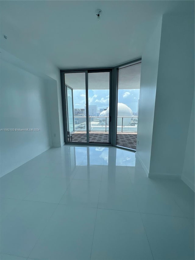 unfurnished room with light tile flooring and expansive windows