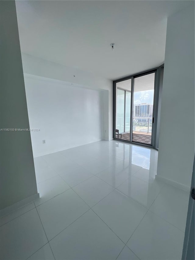 tiled spare room featuring expansive windows