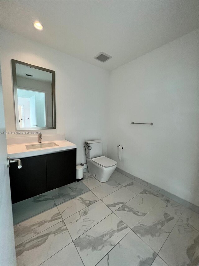 bathroom with vanity, tile floors, and toilet