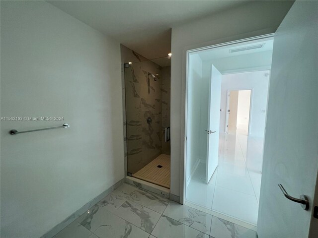 bathroom featuring tile floors and a shower with shower door