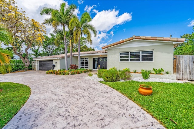 ranch-style home with a front lawn and a garage