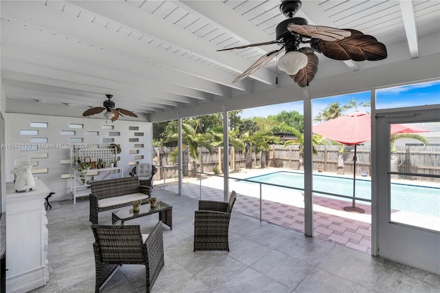 sunroom featuring ceiling fan, a pool, and beamed ceiling