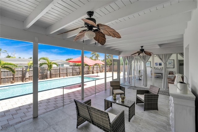 sunroom featuring ceiling fan, a pool, and beamed ceiling